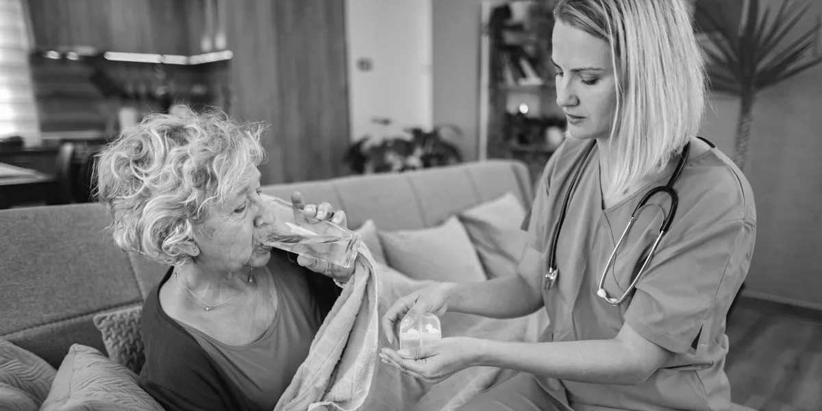 Caregiver assisting elderly woman at home
