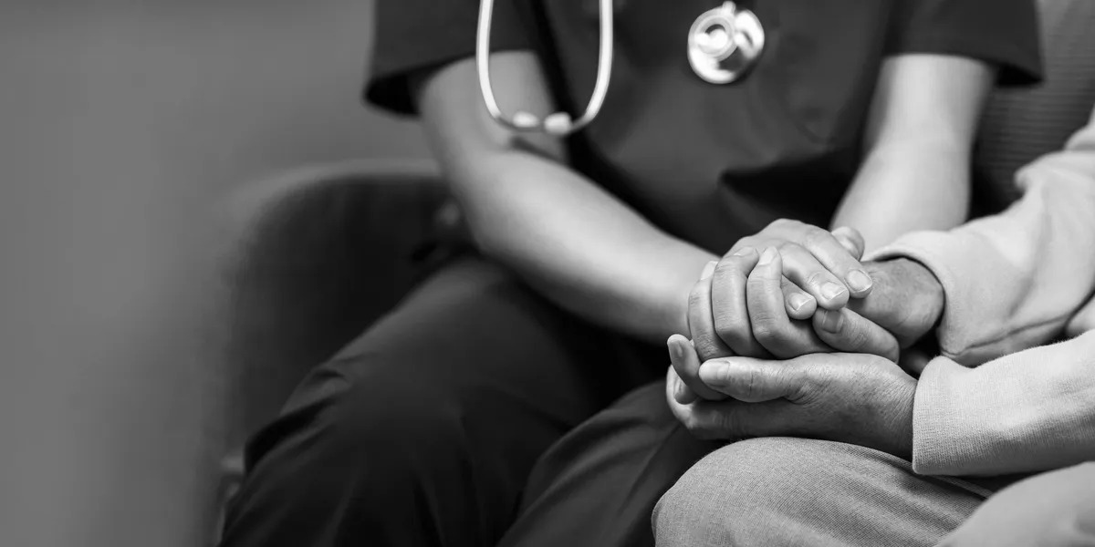 Caregiver holding patient hands with compassion
